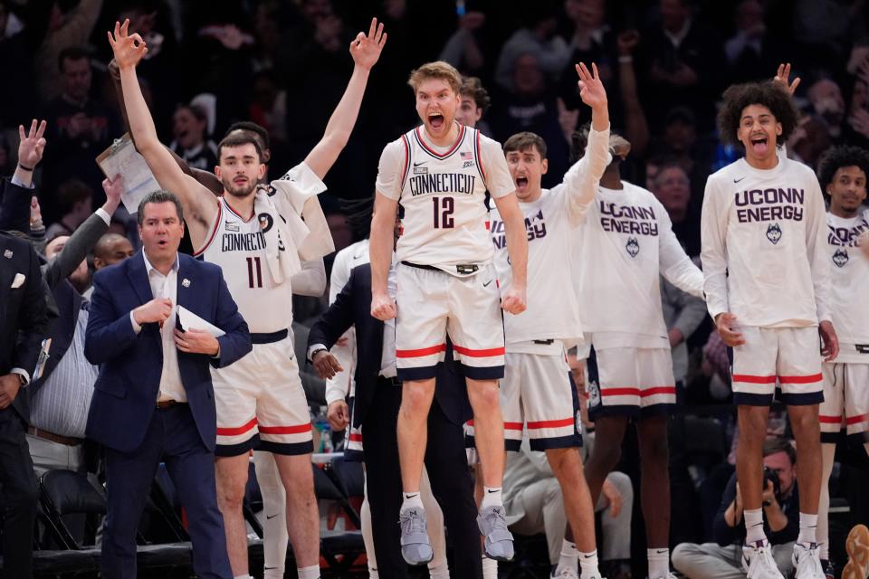 UConn guard Cam Spencer (12) and teammates celebrate during the final minutes of the team's game against Marquette.