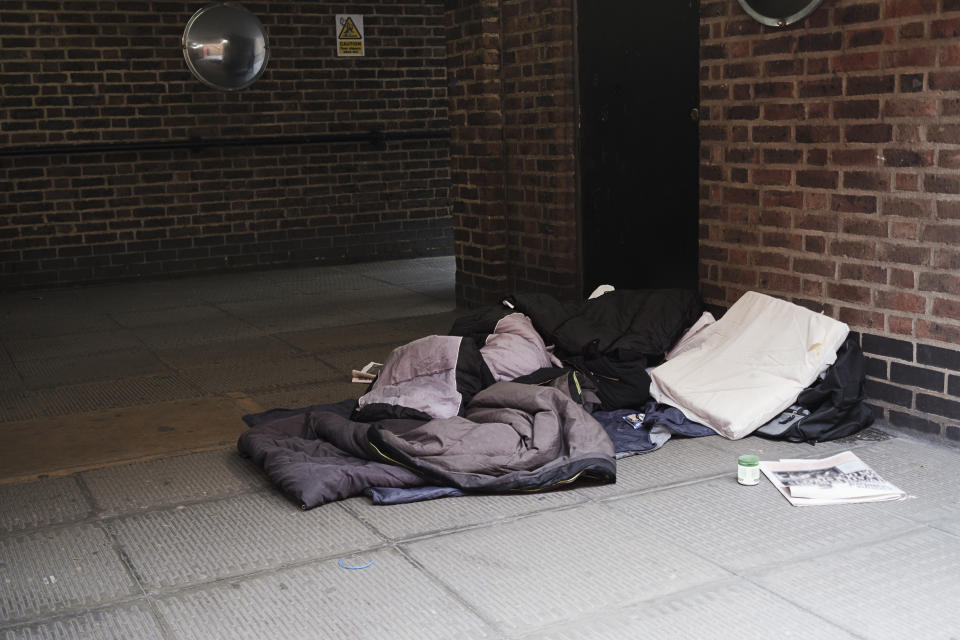 High angle view of sleeping bag on footpath by brick wall in city