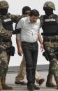 Joaquín "El Chapo" Guzmán, líder del Cártel de Sinaloa, es escoltado hacia un helicóptero con las manos esposadas por infantes de Marina mexicanos en un hangar de la Armada en la Ciudad de México, el sábado 22 de febrero de 2014. (Foto AP/Marco Ugarte)