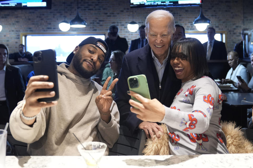 President Joe Biden, center, takes photos with patrons at They Say restaurant during a campaign stop Thursday, Feb. 1, 2024, in Harper Woods, Mich. (AP Photo/Evan Vucci)