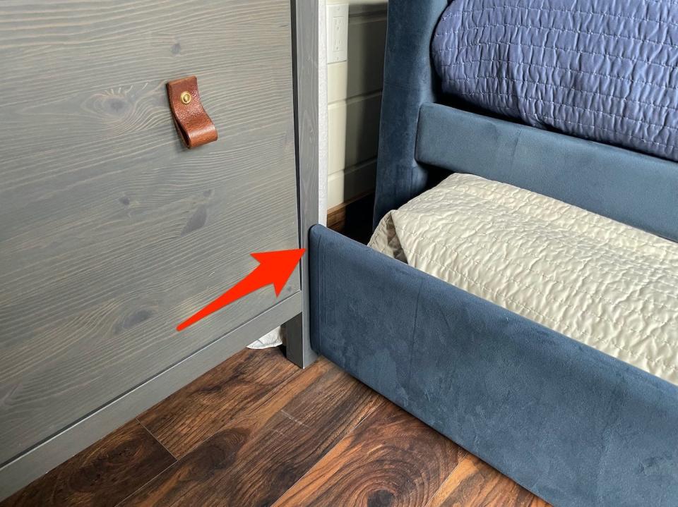 An arrow points to how perfectly the trundle and dresser fit in the living area.