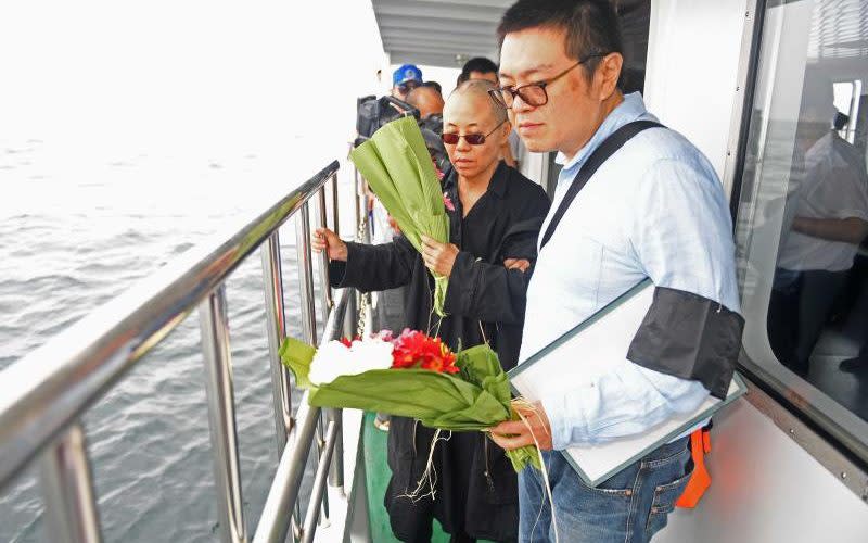 The dissident's wife Liu Xia, centre, scattered his ashes into the sea - Credit: EPA/SHENYANG MUNCIPAL INFORMATION OFFICE