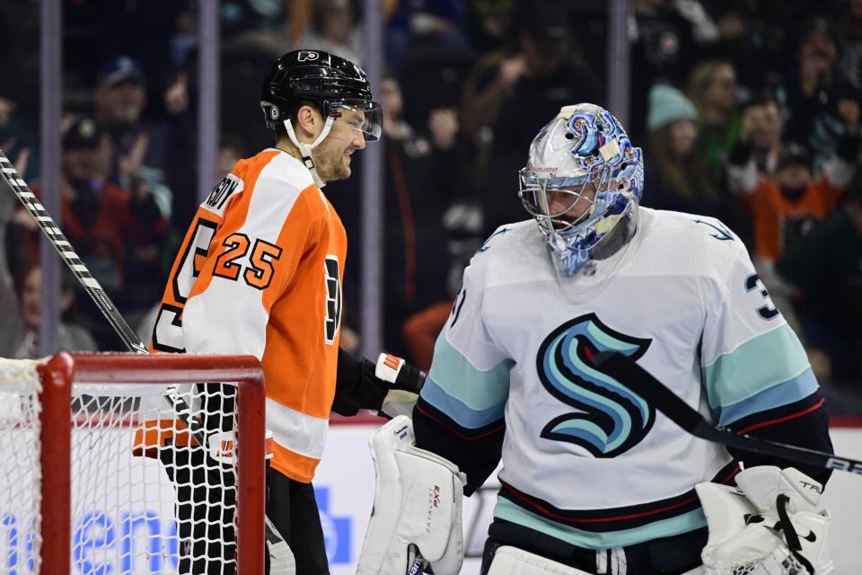 Philadelphia Flyers' James van Riemsdyk, left, smiles after scoring a goal past Seattle Kraken goaltender Philipp Grubauer during the second period an NHL hockey game, Sunday, Feb. 12, 2023, in Philadelphia. (AP Photo/Derik Hamilton)