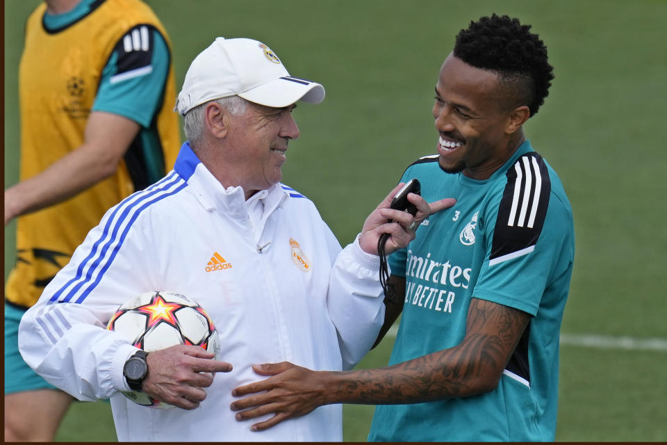 Real Madrid's head coach Carlo Ancelotti, left, talks with Real Madrid's Eder Militao during a Media Opening day training session in Madrid, Spain, Tuesday, May 24, 2022. Real Madrid will play Liverpool in Saturday's Champions League soccer final in Paris. (AP Photo/Manu Fernandez)