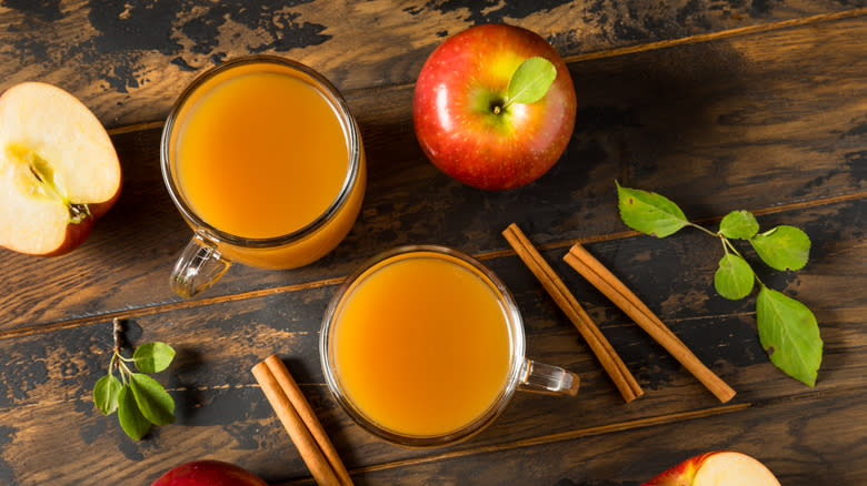 Apples, leaves, and glasses of apple cider from above