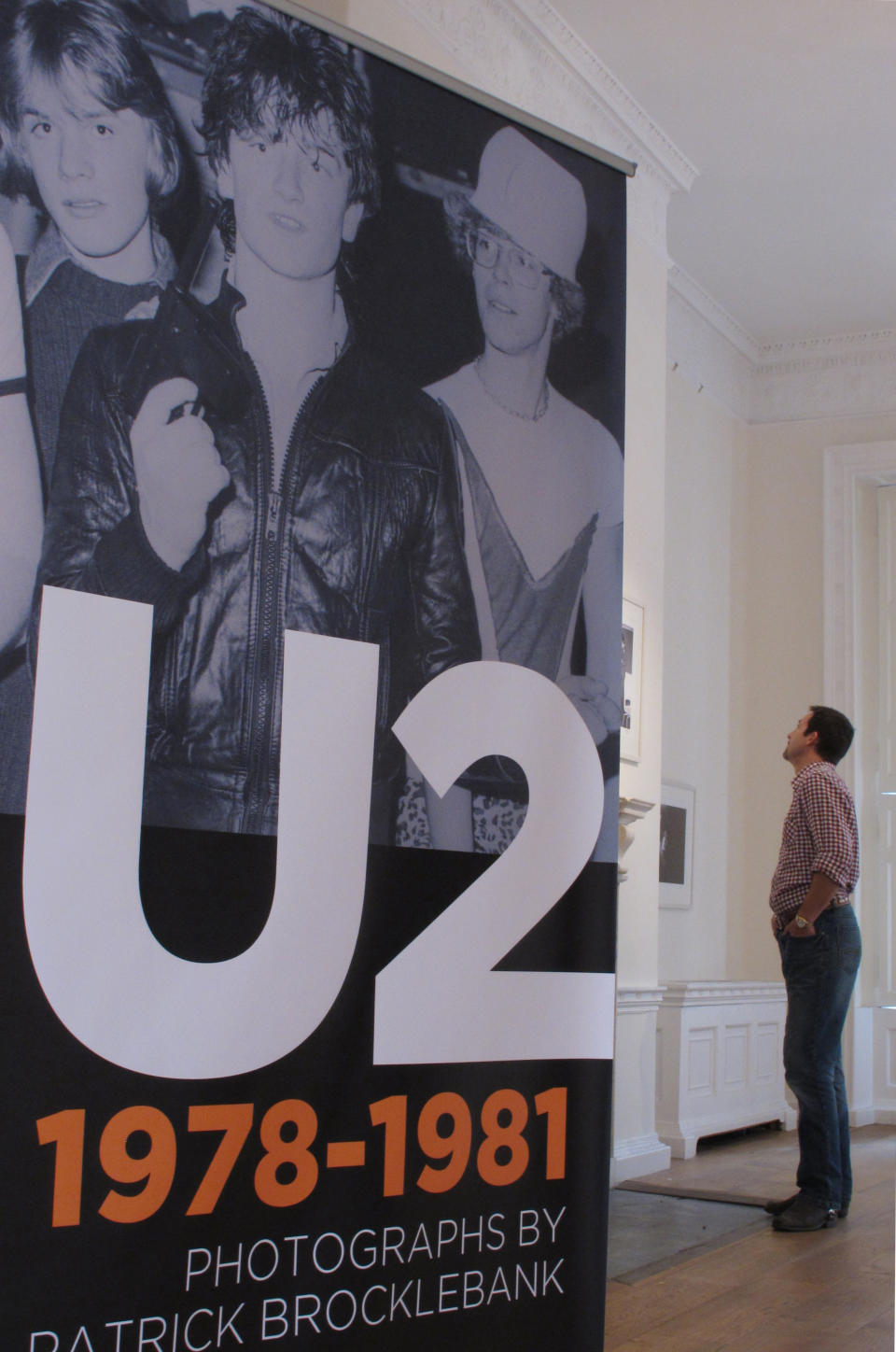 CORRECTING NAME TO BROCKLEBANK - A man inspects early photographs of Irish supergroup U2 before the official opening of the ``U2 1978-1981'' photo exhibition in Dublin, Ireland, on Thursday, May 10, 2012. The Little Museum of Dublin is displaying a collection of pictures by photographer Patrick Brocklebank, documenting the gritty beginnings of U2 in the smoky pubs and clubs of Dublin before the Irish band became and international supergroup of today. (AP Photo/Shawn Pogatchnik)