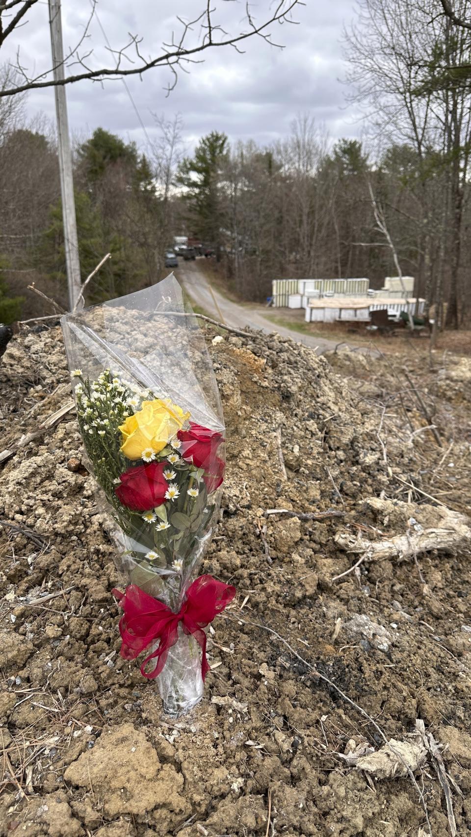 A lone bouquet of flowers marks a desolate makeshift memorial at the end of a driveway to a multiple-fatalities crime scene in Bowdoin, Maine, on Wednesday, April 19, 2023. A Maine man who police say killed four people in a home and then shot three others randomly on a busy highway had been released days earlier from prison, a state official said Wednesday. (AP Photo/Rodrique Ngowi)