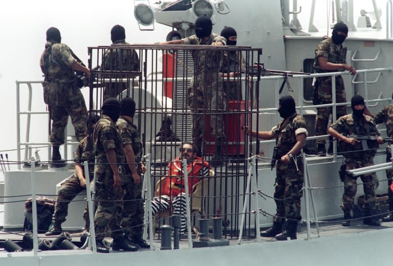 Abimael Guzman (in cage), leader and founder of the Maoist Shining Path guerrilla group, is surrounded by members of the Peruvian special forces near Lima as he is transferred by boat from his island jail to a mainland prison