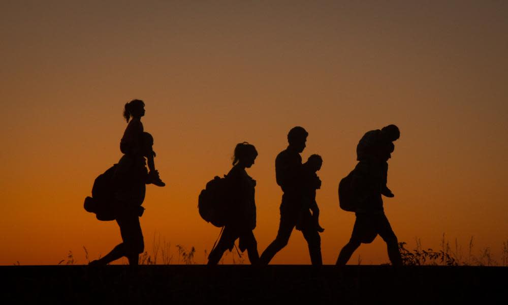 Refugees walk along a railway line after crossing the border from Serbia into Hungary in August 2015.