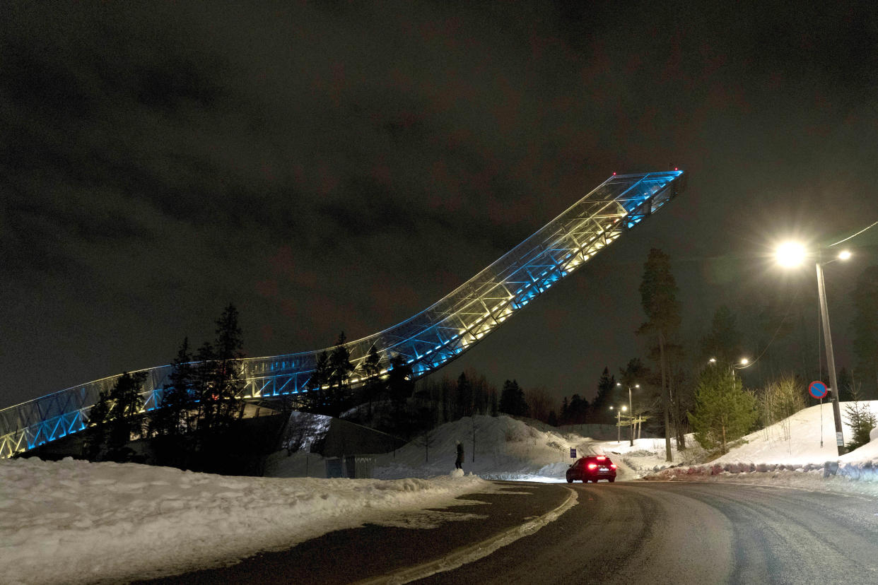 A view of Holmenkollen ski jumping hill lit up in the colors of the Ukrainian flag, to show support for Ukraine in light of Russia's invasion of the country, in Oslo, Monday, Feb. 28, 2022. Norway challenged a decision by the International Ski Federation to allow Russians to keep competing, and said it would block them from upcoming rounds of the World Cup that Norway hosts this week. (Terje Pedersen/NTB via AP)