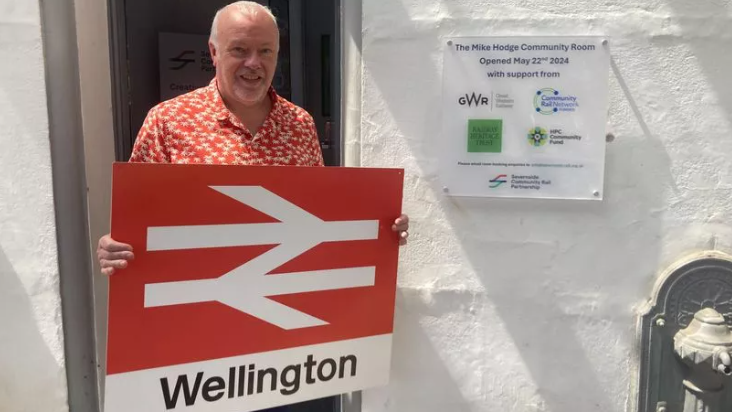 David Northey holds the new Wellington railway sign