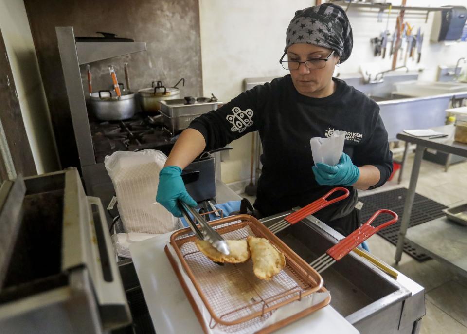 Maria Calovang, owner of Boriken Mart, takes an empanada out of a deep fryer on Dec. 3 at Boriken Mart in Wausau. Calovang opened the restaurant after running a food truck under the same name.