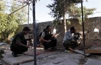 Free Syrian Army fighters take up positions with their weapons behind a wall in Aleppo's Sheikh Saeed neighbourhood September 9, 2013. REUTERS/Nour Kelze