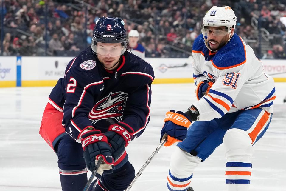 Mar 7, 2024; Columbus, Ohio, USA; Columbus Blue Jackets defenseman Andrew Peeke (2) fights for the puck with Edmonton Oilers left wing Evander Kane (91) during the NHL hockey game at Nationwide Arena.