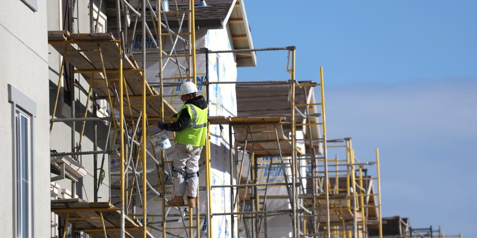 A worker makes repairs to a home under construction in Newark, California.