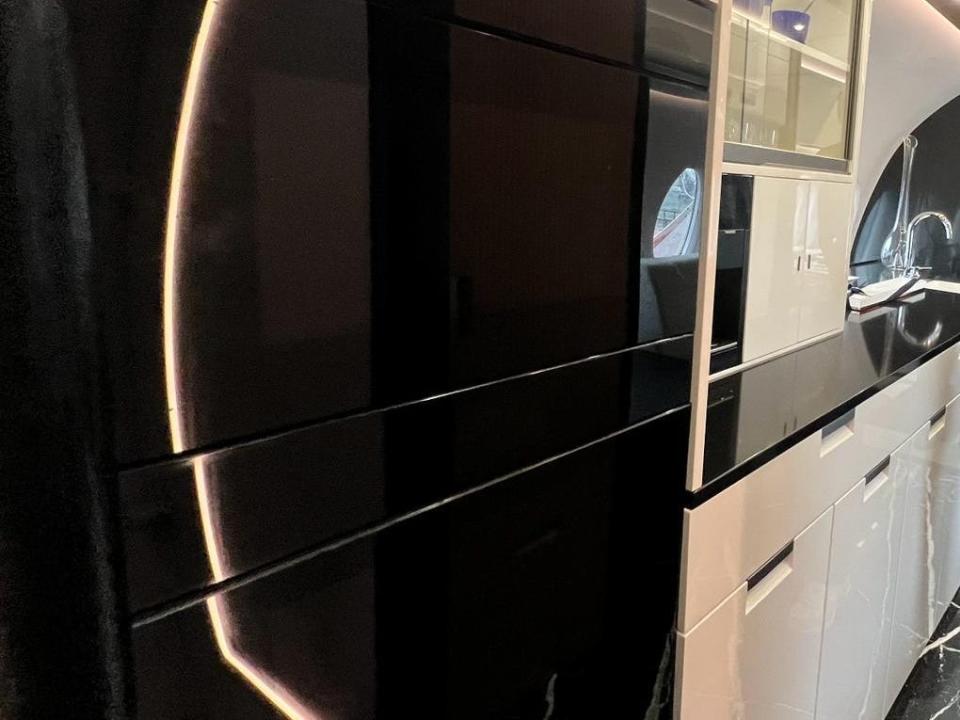 Two black convection ovens in the galley of a Falcon 10X, and the white cabinets in the background.
