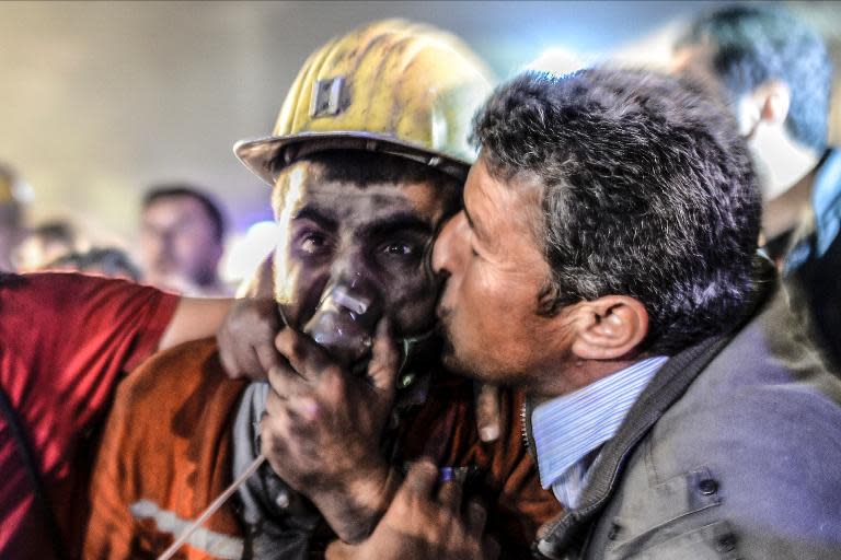 A man kisses his son, rescued from the mine, after an explosion in a coal mine in Manisa, on May 13, 2014