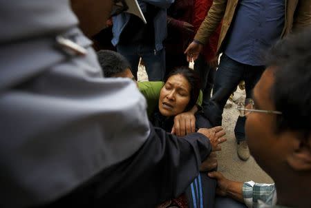 A woman cries as her son was trapped inside a collapsed house after an earthquake hit, in Kathmandu, Nepal April 25, 2015. REUTERS/Navesh Chitrakar