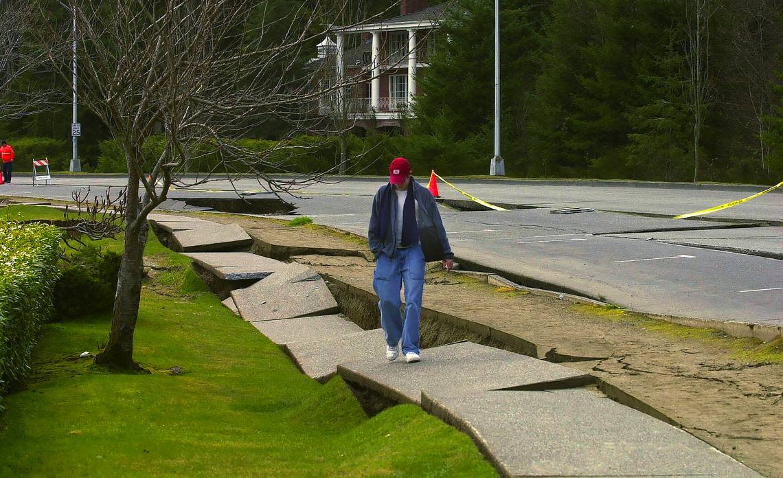 South Puget Sound Community College student Jeff Ennett checks out the detached sidewalk on Deschutes Parkway days after the Nisqually earthquake shook the area the morning of Feb. 28, 2001. The magnitude 6.8 earthquake lasted 40 seconds, injured 400 and caused about $2 billion in damages. Sunday marks the 20th anniversary of the quake.