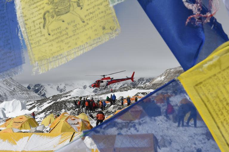 Prayer flags frame a rescue helicopter as it ferries the injured from Everest Base Camp on April 26, 2015, a day after an avalanche triggered by an earthquake devastated the camp