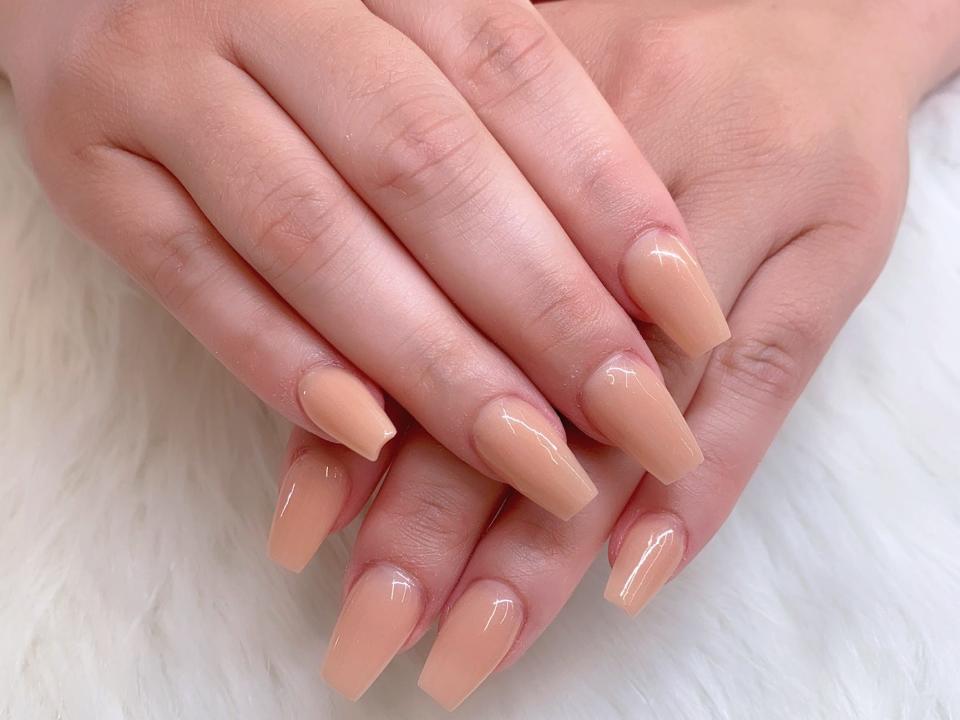 Nude-colored manicure.