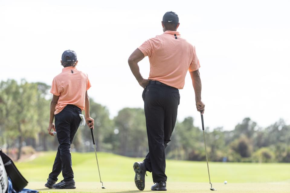 Tiger Woods and his son Charlie wait to putt on the third green of the Ritz-Carlton Golf Club in Orlando at the 2021 PNC Father-Son Championship.