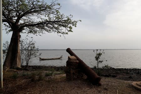 Fisherman works in his boat as he fishes beside Kunta Kinteh Island, in the Gambia River, near Jufureh, Albreda