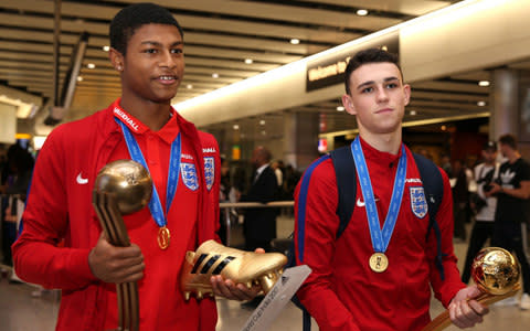Rhian Brewster (left) and Phil Foden (right) arriving back at Heathrow - Credit: PA