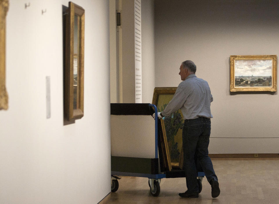 A curator removes Vincent van Gogh paintings on a carrier trolley at the Van Gogh Museum in Amsterdam, Netherlands, Sunday, Sept. 23, 2012. While the museum closes for seven months for renovations, 75 works by the Dutch painter will be displayed instead across town at The Hermitage, an Amsterdam satellite of the Russian state museum. The tricky process of transporting the artworks under police escort began immediately after the last visitors left the museum Sunday evening and carried on through the night into Monday morning. The Van Gogh Museum reopens April 25, 2013. (AP Photo/Cris Toala Olivares)