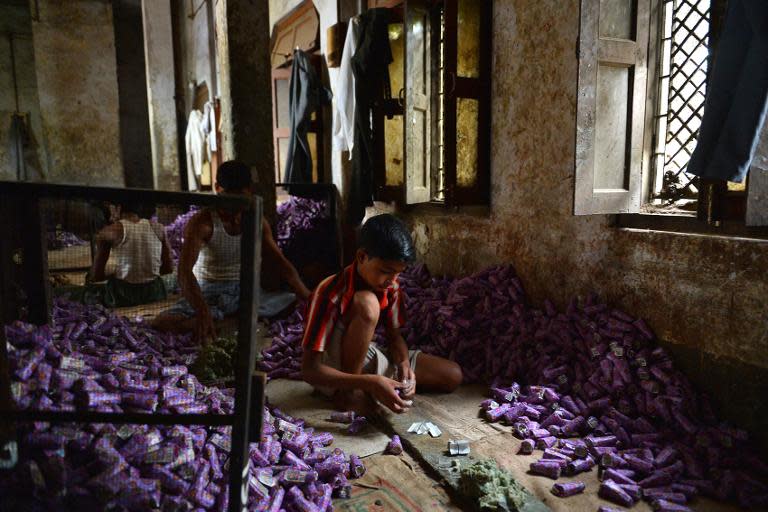 Young Indian labourer packs bidis into colourful conical packets and boxes, at the New Sarkar Bidi Factory in Kannauj, some 200 km south-east of New Delhi