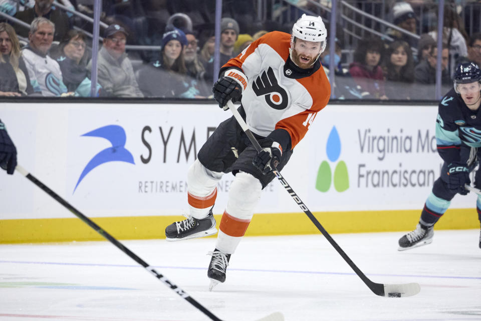 Philadelphia Flyers center Sean Couturier (14) shoots against the Seattle Kraken during the second period of an NHL hockey game Friday, Dec. 29, 2023, in Seattle. (AP Photo/John Froschauer)