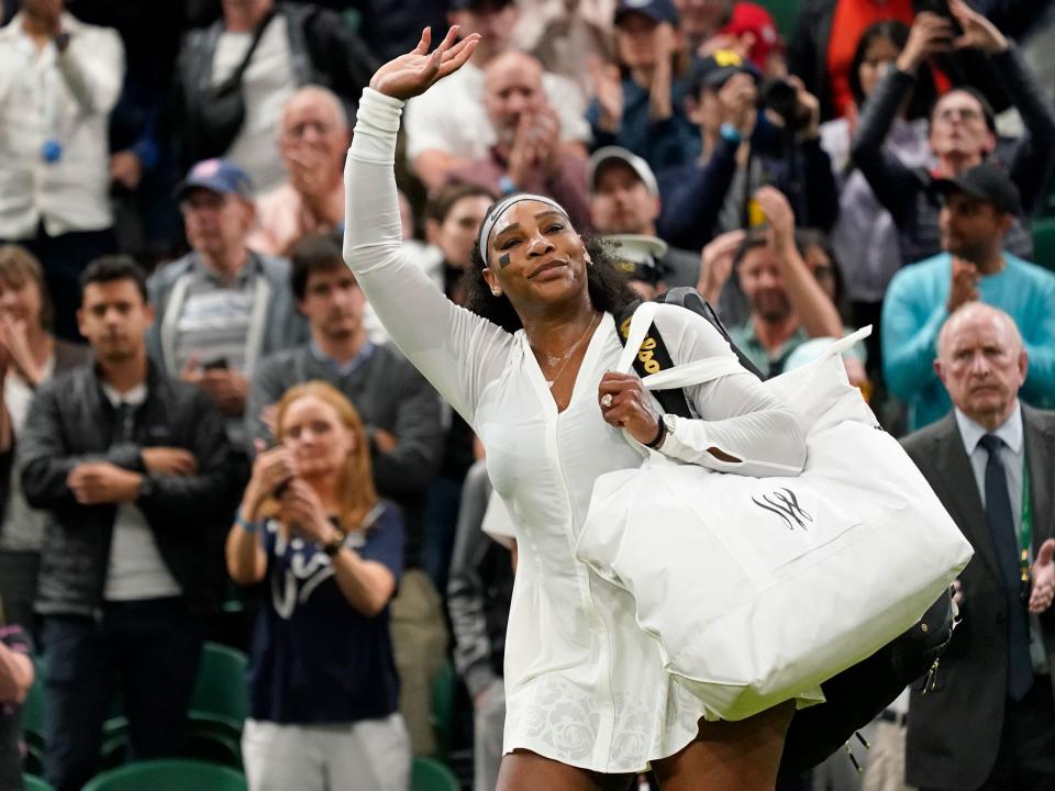 Serena Williams of the US waves as she leaves the court after losing to France's Harmony Tan at Wimbledon 2022.