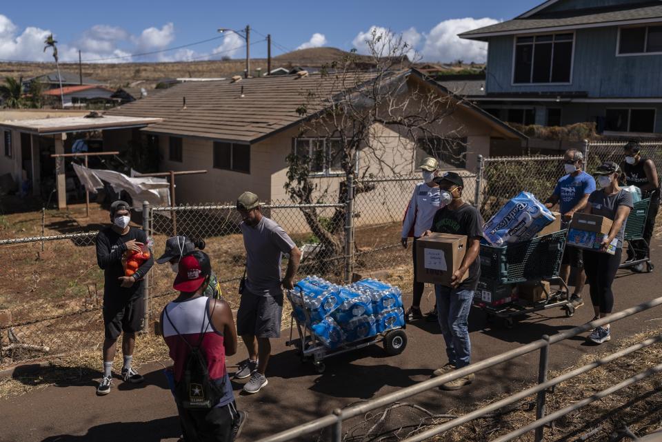 FILE - Volunteers make food, bottle water and supply deliveries to elderly residents impacted by a devastating wildfire in Lahaina, Hawaii, Aug. 19, 2023. Residents of Maui are eager to learn when they can expect safe drinking water to be restored in the wake of last month’s catastrophic wildfires, but extensive testing is still needed and officials are urging patience. (AP Photo/Jae C. Hong, File)