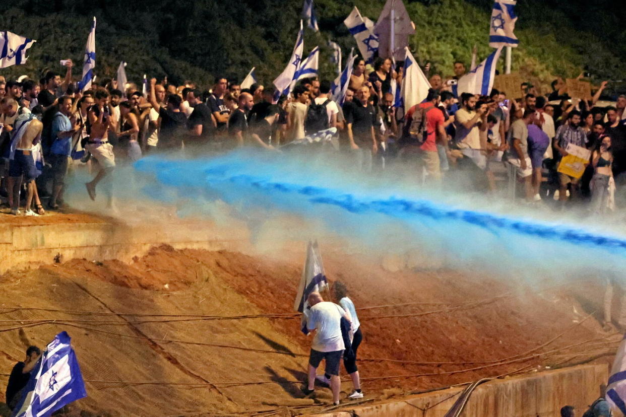 Le 24 juillet 2023, à Tel-Aviv, des manifestants israéliens sont aspergés de « skunk », liquide nauséabond utilisé pour disperser les foules.  - Credit:Jack Guez/AFP