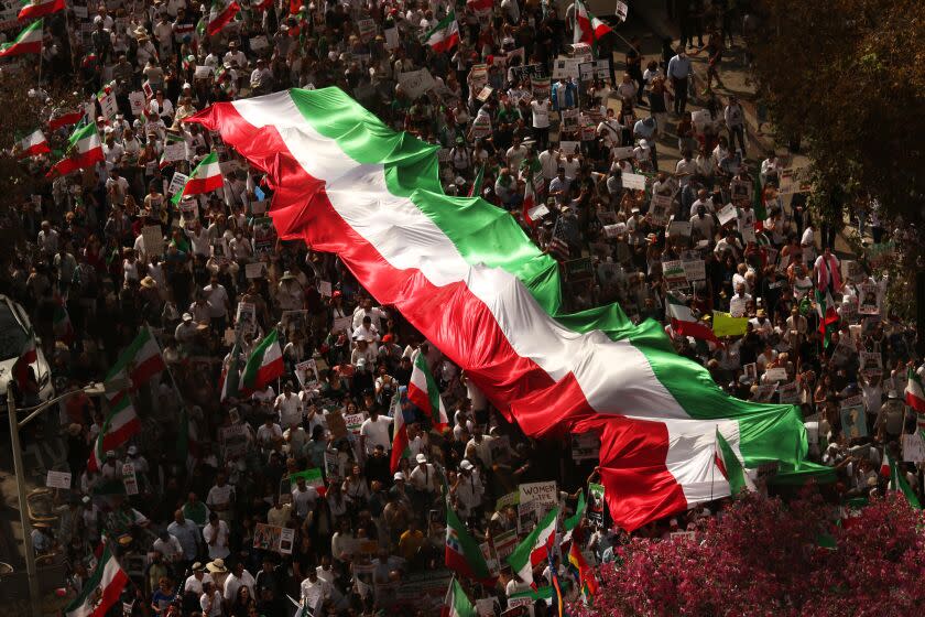 LOS ANGELES, CA - OCTOBER 22, 2022 - - Thousands of Iranian Americans and others, carrying the Iranian flag, march during a Freedom Rally for Iran protesting in solidarity with women-led protests in Iran and for regime change in Iran in downtown Los Angeles on October 22, 2022. They were also protesting the recent death of Mahsa Amini caused during the custody of the Islamic republic's "morality police." The march started at Pershing Square and ended up at City Hall. Similar protests happened all over the world in solidarity with women-led protests in Iran.(Genaro Molina / Los Angeles Times)