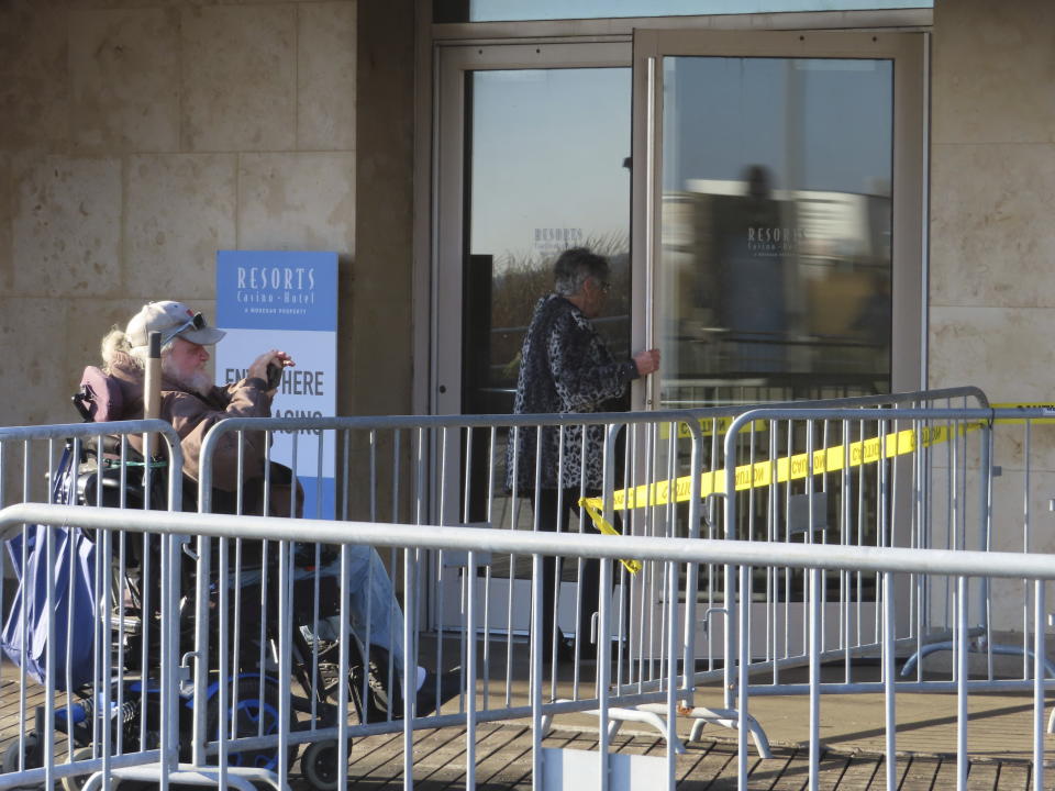 A customer enters Resorts Casino in Atlantic City N.J. through an undamaged door on Nov. 16, 2023, a day after a fire damaged part of the Boardwalk, the casino's entrance and its facade. The casino remained open throughout the incident. (AP Photo/Wayne Parry)