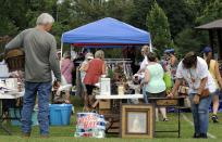 A crowd looks through items at the World's Longest Yard Sale, which stretches from Alabama to Michigan, at its southernmost point in Gadsden, Ala., on Thursday, Aug. 6, 2020. Promoters considered canceling the four-day sale because of the coronavirus pandemic but decided to go ahead with the event, now in its 34th year. (AP Photo/Jay Reeves)