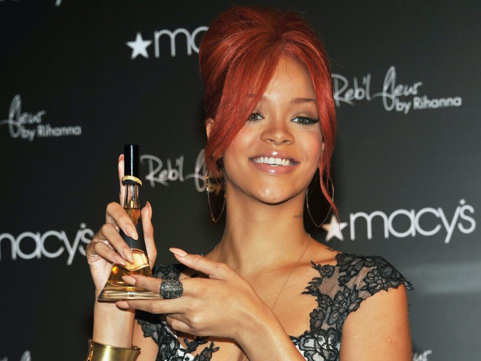 Rihanna holds Reb'l Fleur fragrance bottle at Macy's event