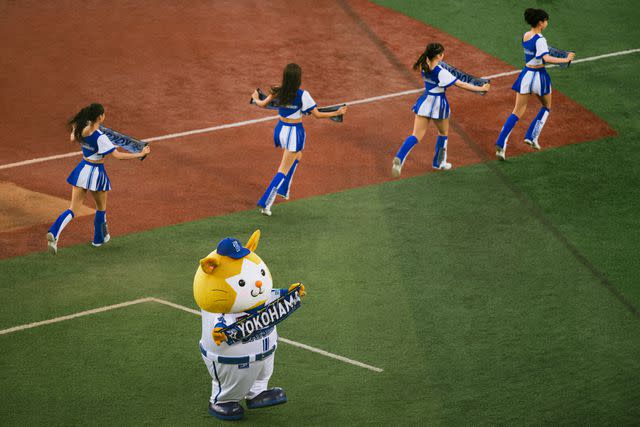 <p>Irwin Wong</p> DB. Starman, the hamster mascot for the Yokohama DeNA BayStars, with a troupe of cheerleaders.