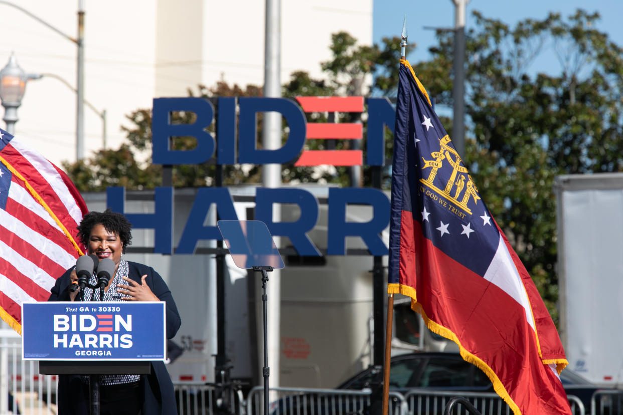 Stacey Abrams speaks at a podium at a Biden/Harris rally