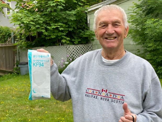 Jake McDonald holds up a package of masks sent to him by the Republic of Korea. McDonald served in the Korean War at the age of 17.