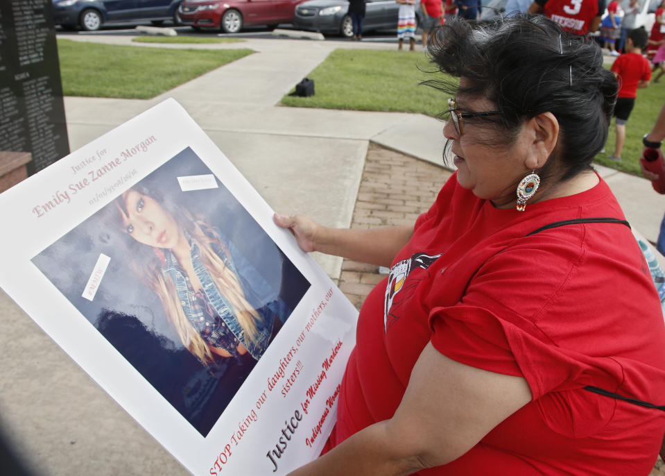 FILE - In this Friday, June 14, 2019, file photo, Carmen Thompson, of El Reno, Okla., looks over a poster of her niece Emily Morgan who was murdered in 2016, before the start of a march to call for justice for missing and murdered indigenous women at the Cheyenne and Arapaho Tribes of Oklahoma in Concho, Okla. U.S. Senate staffers say officials missed a second deadline on July 8 to offer input on bills on Native American safety, and only one department has since provided “partial comment.” (AP Photo/Sue Ogrocki, File)