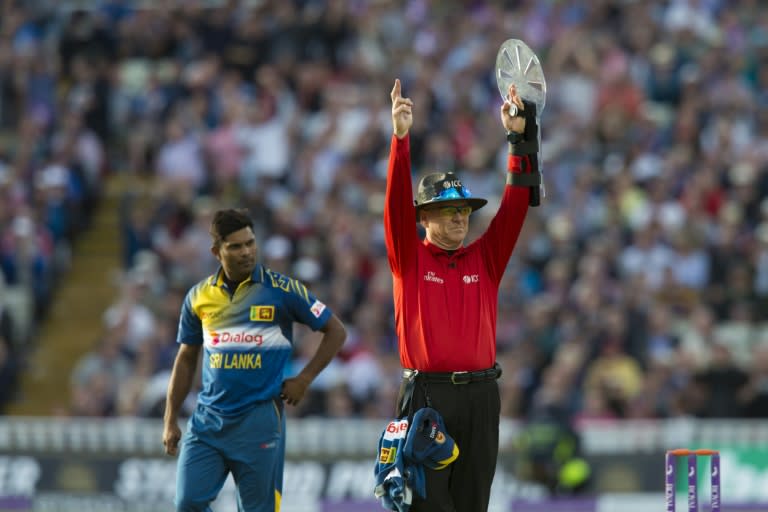 Sri Lanaka's Seekkuge Prasanna (L) walks past umpire Bruce Oxenford during play in the second one day international cricket match between England and Sri Lanka, on June 24, 2016