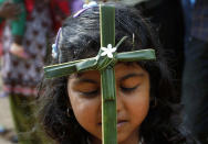 An Indian Christian girl holds a cross made of blessed palm during a Palm Sunday mass at a church in Bhubaneswar, India, Sunday, April 13, 2014. Palm Sunday's liturgy recalls Jesus' triumphant entry into Jerusalem. (AP Photo/Biswaranjan Rout)