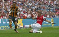 Hull City's Ahmed Elmohamdy (L) is challenged by Arsenal's Lukas Podolski during their FA Cup final soccer match at Wembley Stadium in London, May 17, 2014. REUTERS/Darren Staples (BRITAIN - Tags: SPORT SOCCER)