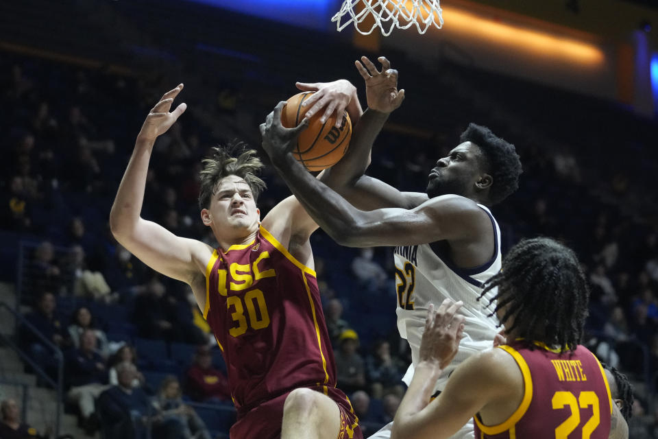 FILE - Southern California forward Harrison Hornery (30), left, of Australia, and California forward ND Okafor (22) compete for a rebound during the first half of an NCAA college basketball game in Berkeley, Calif., Wednesday, Nov. 30, 2022. College athletes from foreign countries have been left out of the rush for endorsement deals because student visa rules largely prohibit work while in the U.S. But a growing number are pursuing a loophole: they can profit from use of their name, image and likeness (NIL) when traveling internationally and are not on U.S. soil. (AP Photo/Godofredo A. Vásquez, File)