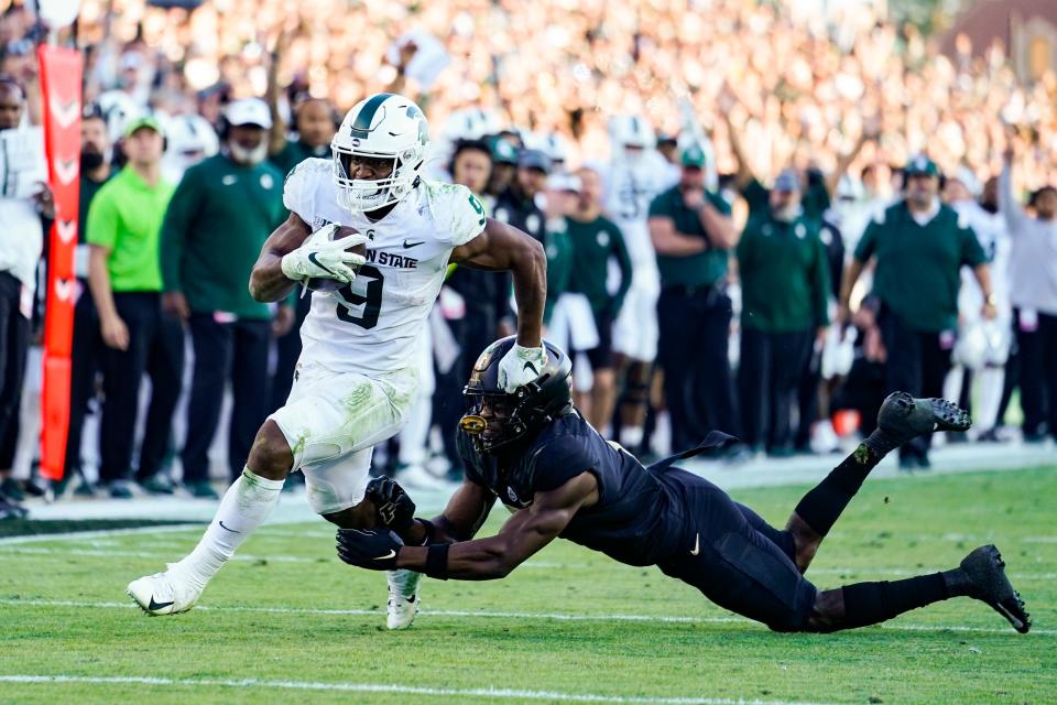 Michigan State running back Kenneth Walker III (9) breaks the tackle of Purdue cornerback Jamari Brown (7) on his way to a touchdown during the first half of an NCAA college football game in West Lafayette, Ind., Saturday, Nov. 6, 2021.