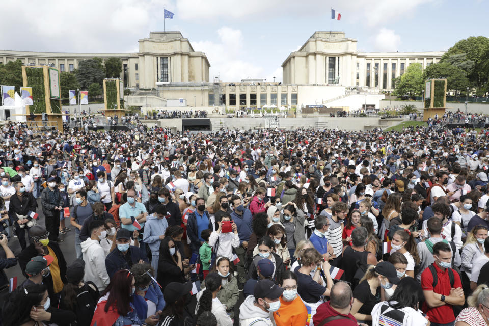 People gather in the Olympics fan zone at the Trocadero in Paris, Sunday, Aug. 8, 2021. A giant flag will be unfurled on the Eiffel Tower in Paris Sunday as part of the handover ceremony of Tokyo 2020 to Paris 2024, as Paris will be the next Summer Games host in 2024. The passing of the hosting baton will be split between the Olympic Stadium in Tokyo and a public party and concert in Paris. (AP Photo/Adrienne Surprenant)