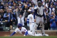 Chicago Cubs second baseman Nico Hoerner scores past Milwaukeee Brewers catcher William Contreras on a single by Chicago Cubs shortstop Dansby Swanson during the third inning of a baseball game Thursday, March 30, 2023, in Chicago. (AP Photo/Erin Hooley)