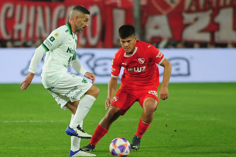 Sergio Ortíz, de Independiente, trata de frenar el avance de Lisandro López, de Sarmiento